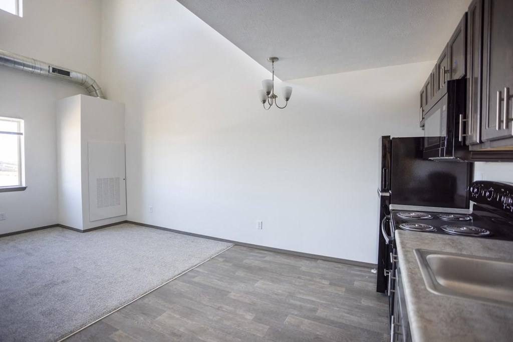 a kitchen and living room with a stove and a refrigerator