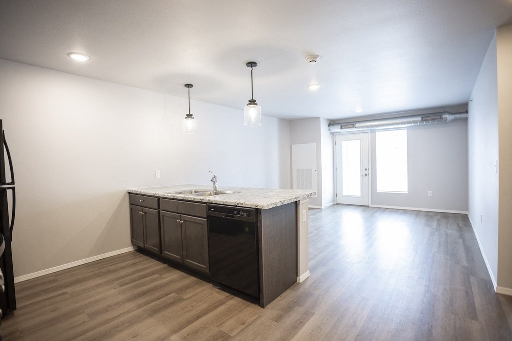 Spacious, combined kitchen and living room with breakfast bar seating.