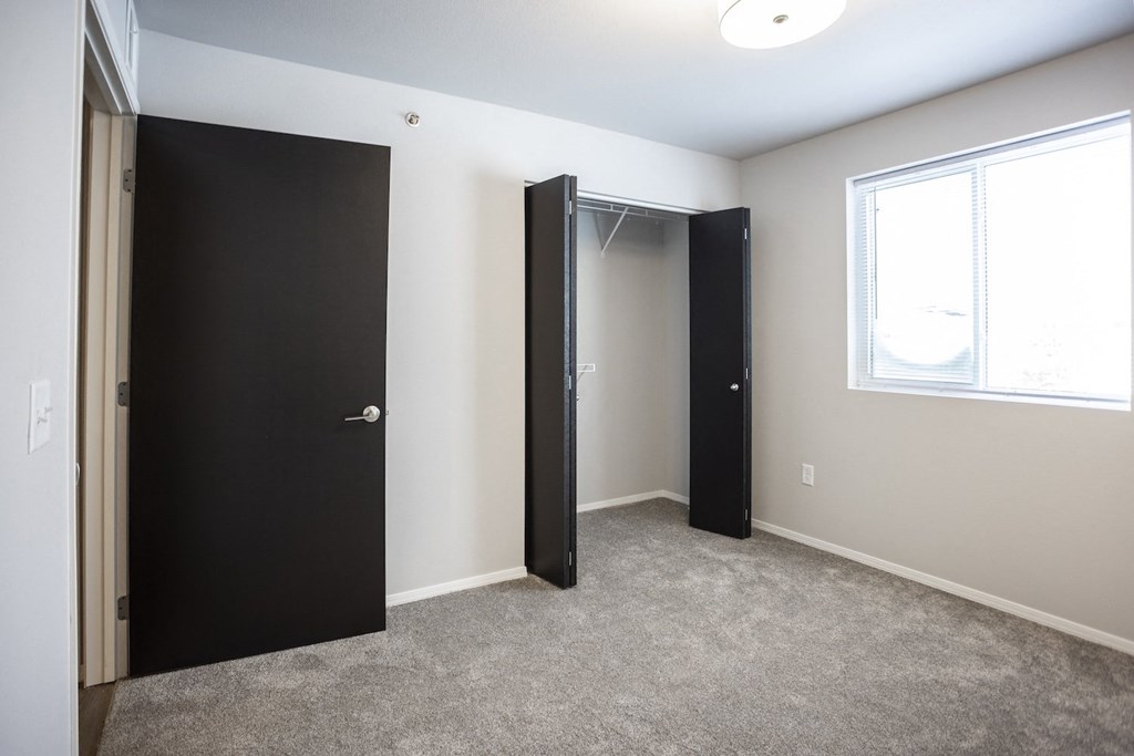 Spacious bedroom with neutral walls and ample natural light.