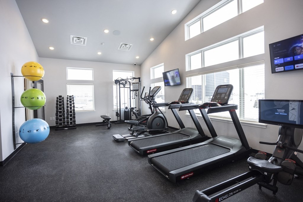 Modern gym with rows of cardio equipment.