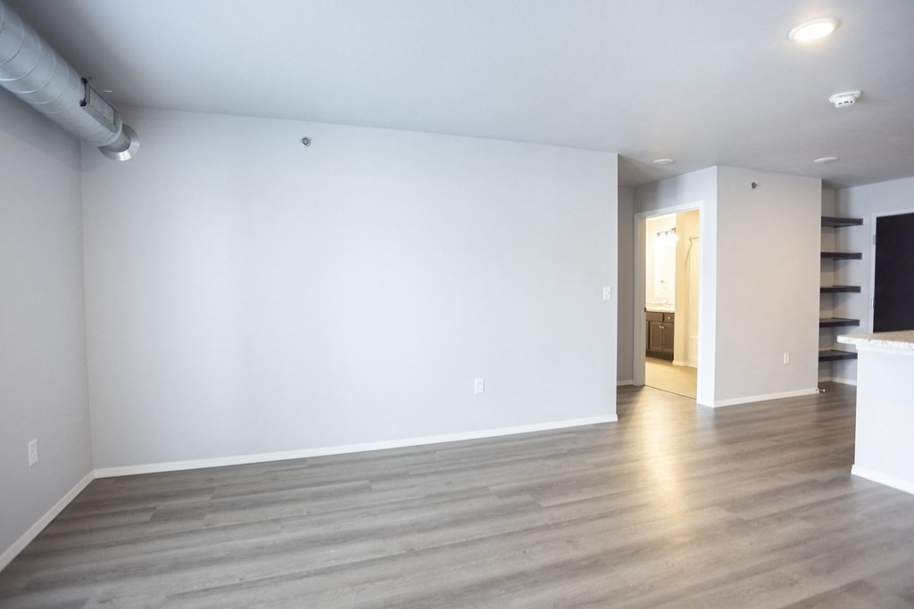 Empty living room with large, bright windows.