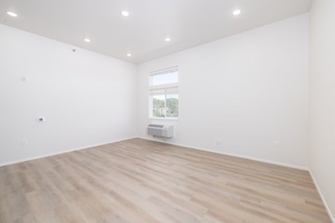 A room with wooden flooring and a window.