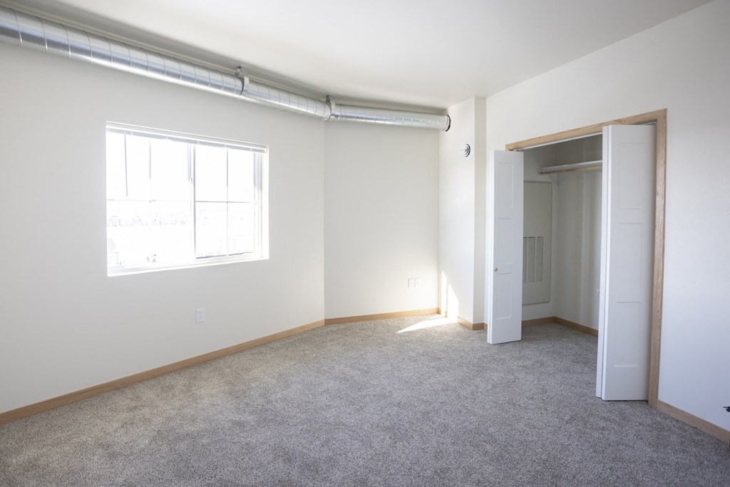 an empty room with white walls and a window