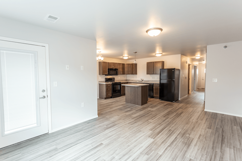 a kitchen and living room with a wood floor and a refrigerator