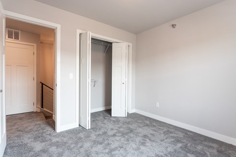 an empty bedroom with a closet and an open door