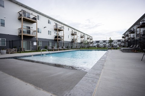 a pool is shown in front of an apartment building