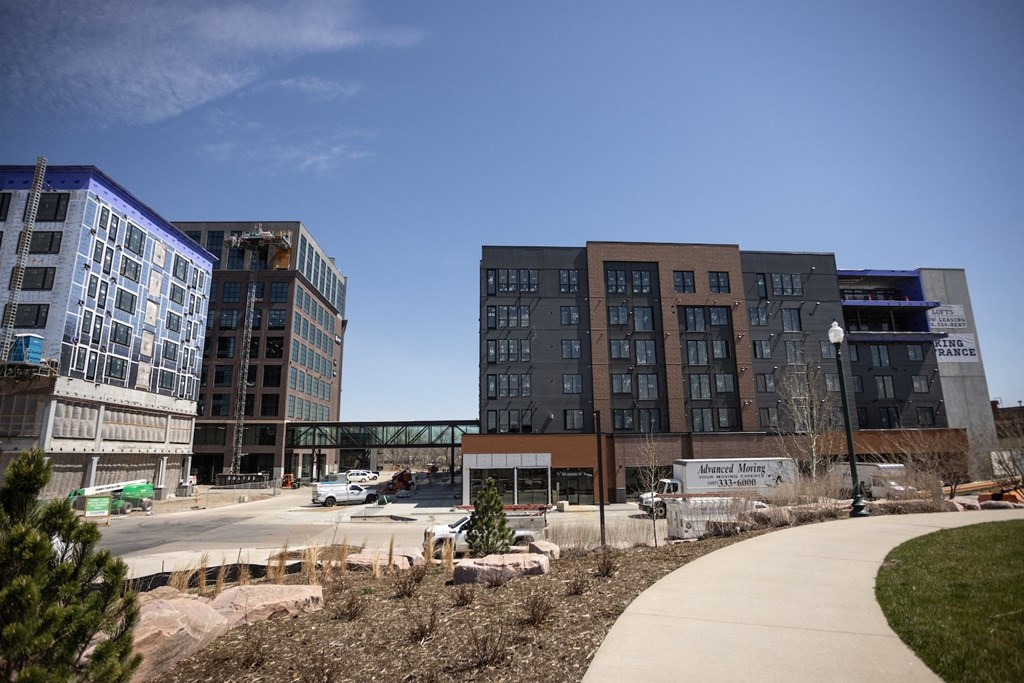 a view of the new building at the intersection of a sidewalk and a street