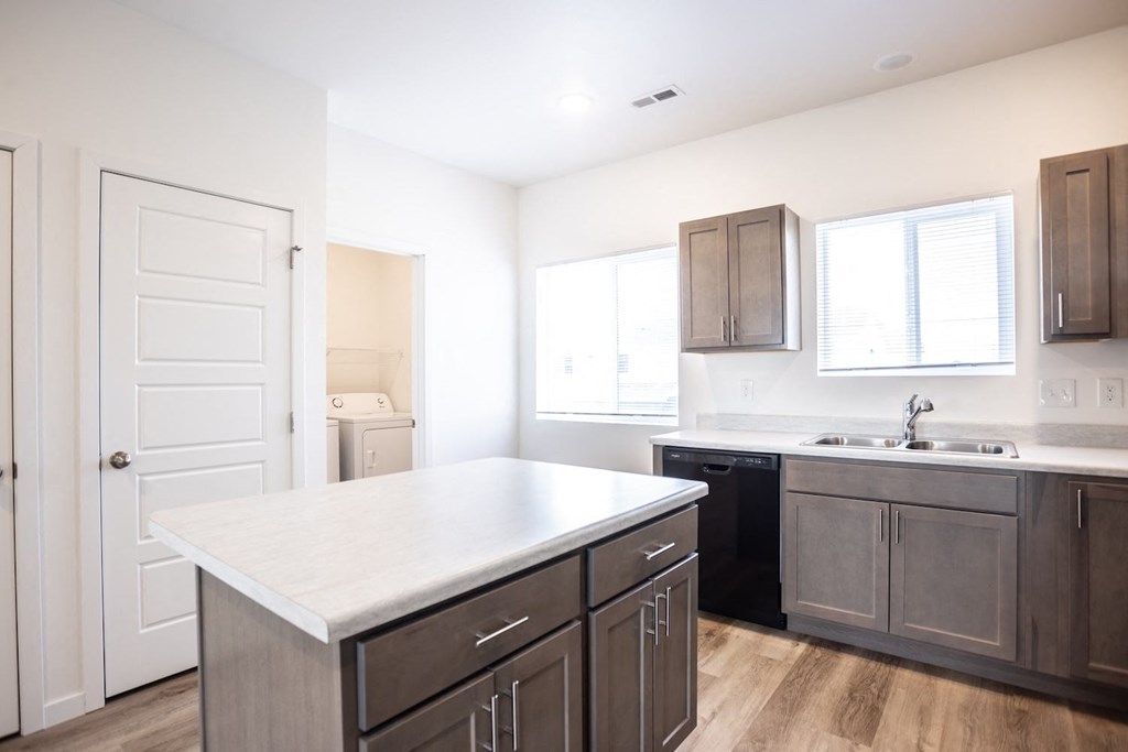 a kitchen with a white counter top and dark cabinets