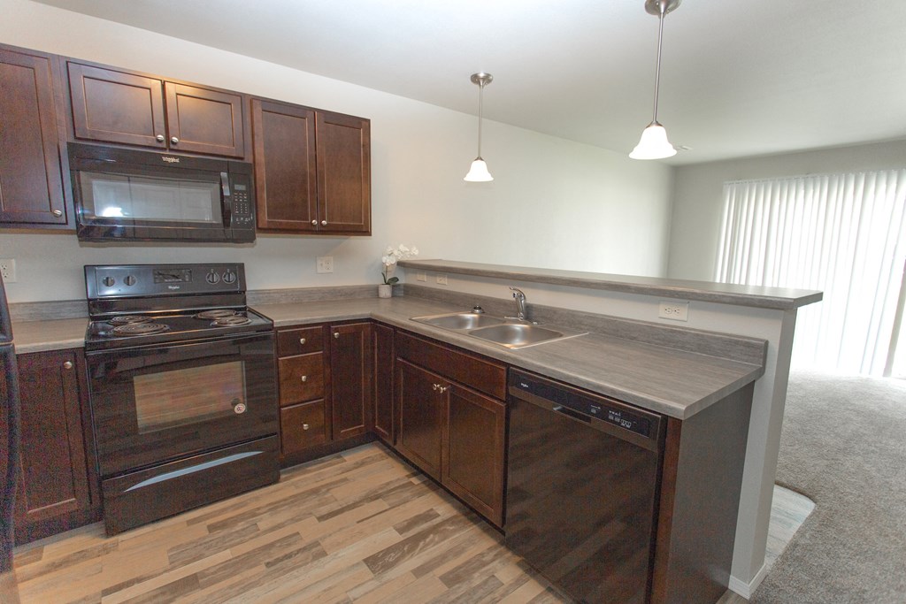a kitchen with wooden cabinets and a stove and a sink