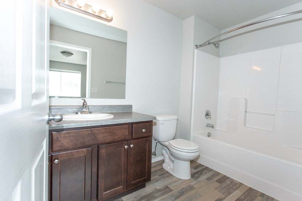 a bathroom with a toilet sink and shower and a mirror