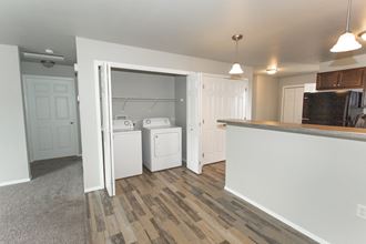 an open kitchen and laundry room with washer and dryer