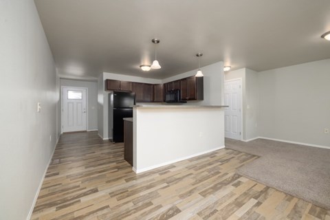 A kitchen with a white counter and wooden flooring.