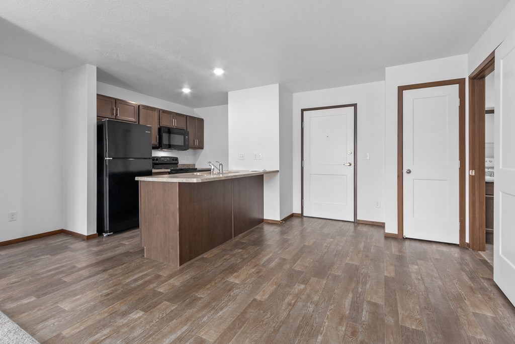 A kitchen with a refrigerator, microwave, and oven.