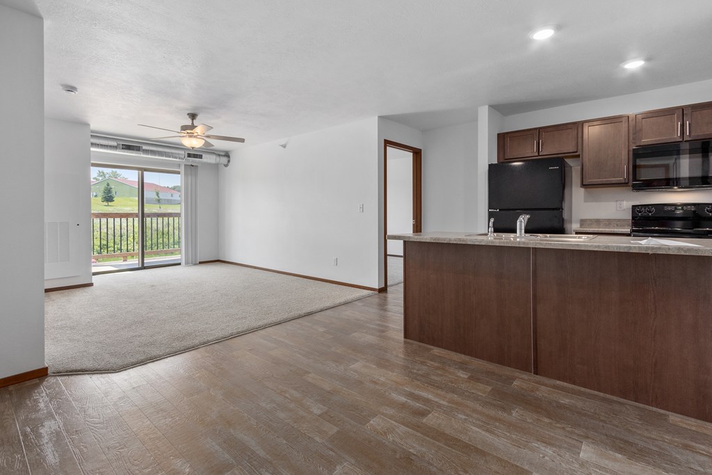 A kitchen with brown cabinets and a black countertop.