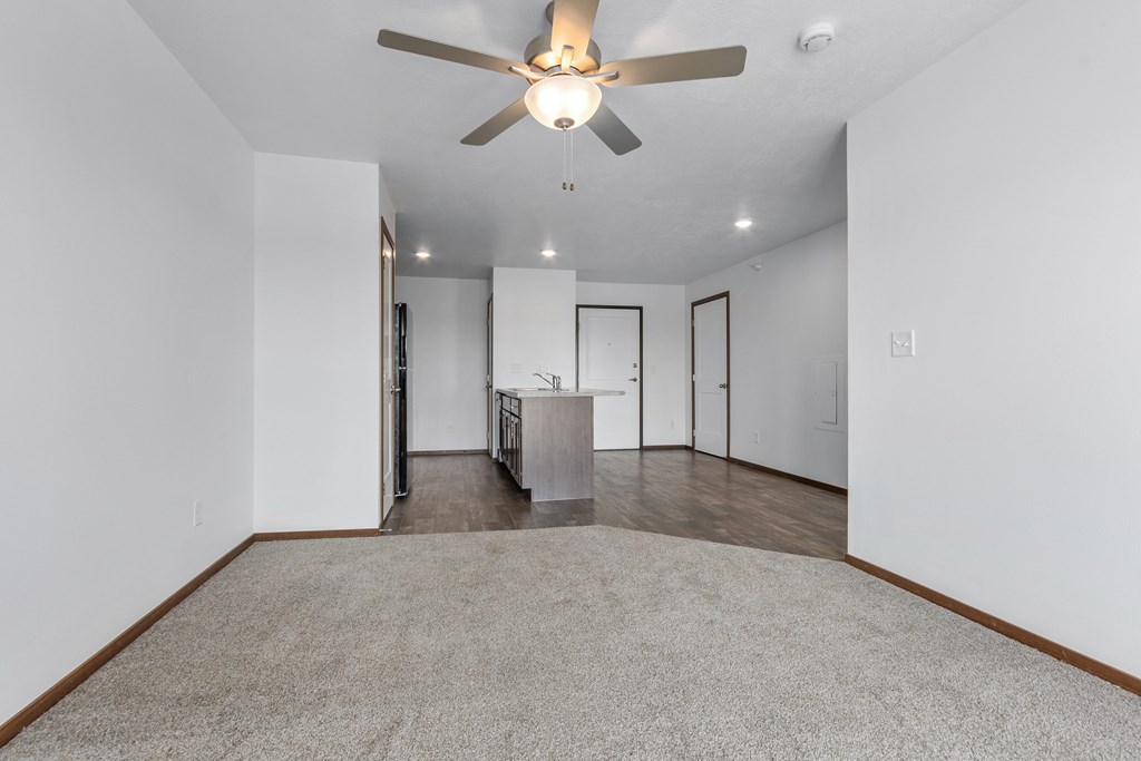 A room with a ceiling fan and a carpeted floor.