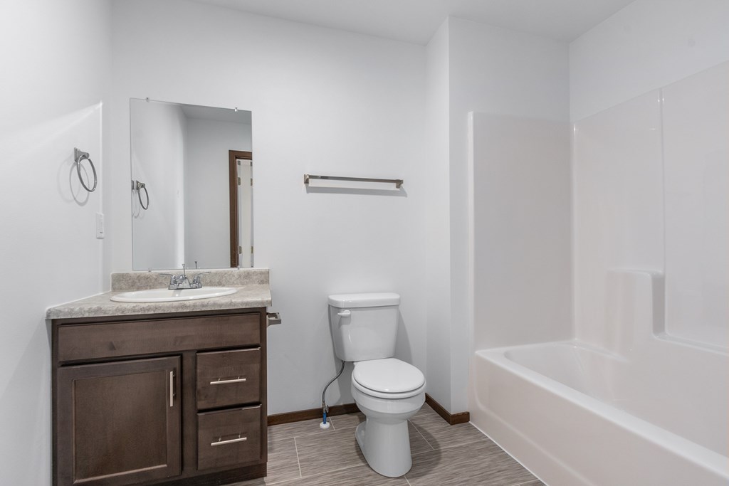 A white bathroom with a toilet, sink, and bathtub.