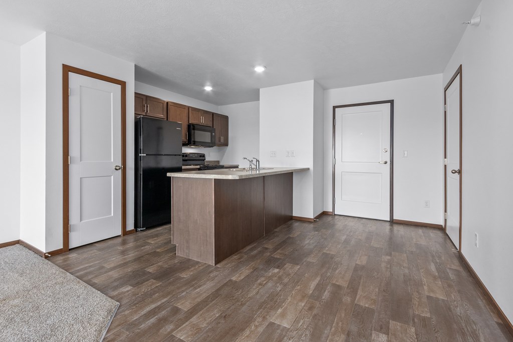 A kitchen with a refrigerator, microwave, and oven.