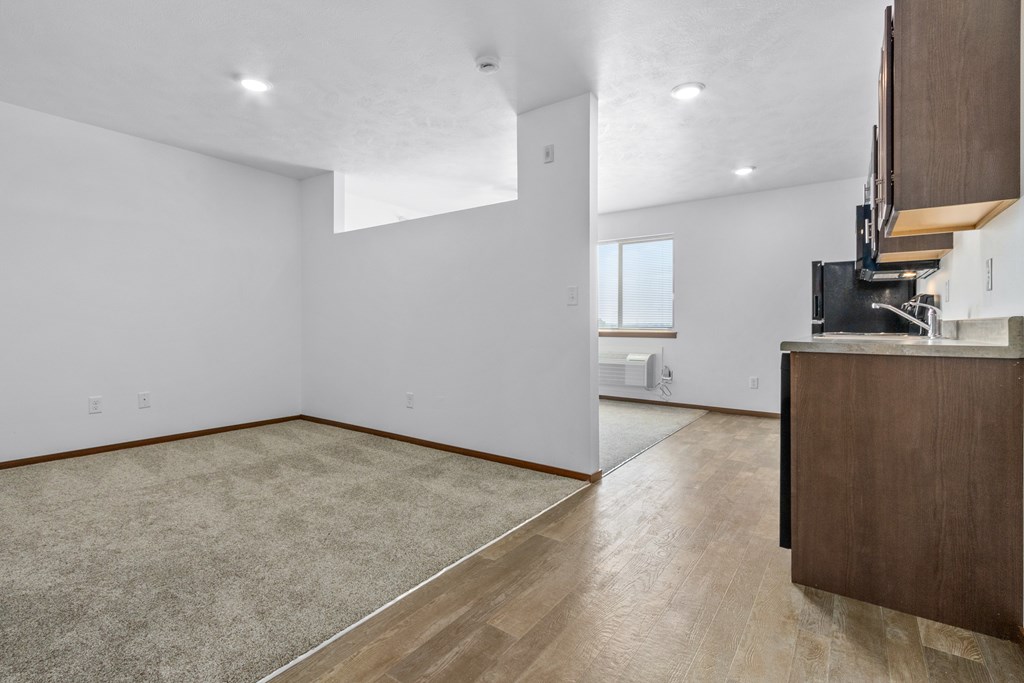 A room with a carpeted floor and a wooden cabinet.