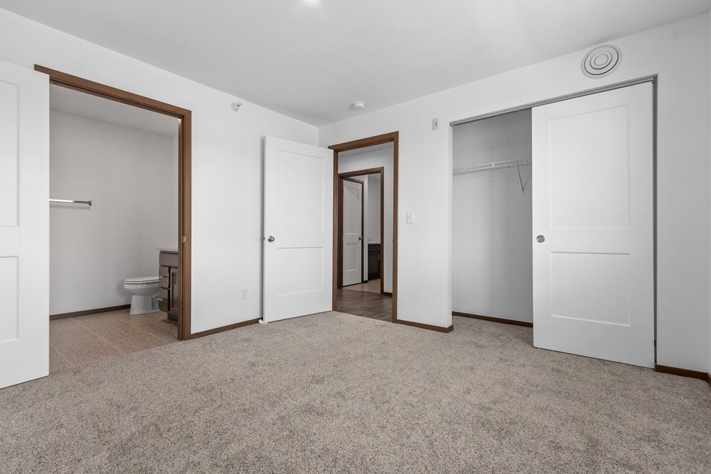 A spacious room with carpeted floor and white walls.