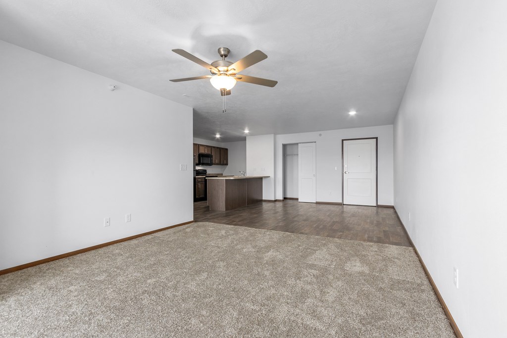 A room with a ceiling fan and a carpeted floor.