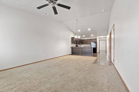 A spacious room with a ceiling fan and a carpeted floor.