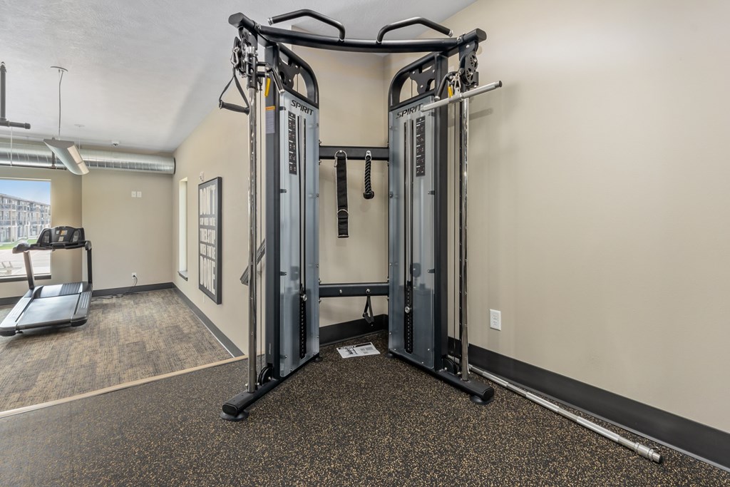 A gym with a treadmill, a weight machine and a treadmill.