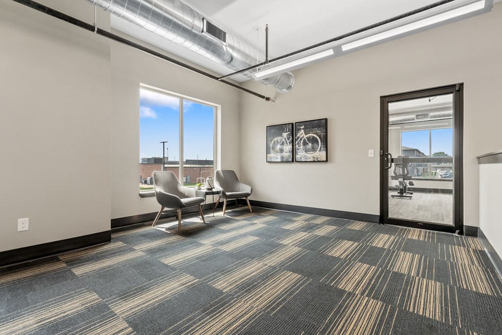 A room with a carpeted floor and a view of the outside through a window.