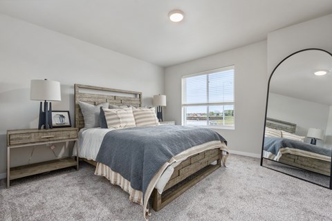 A bedroom with a large bed and a mirror on the wall.
