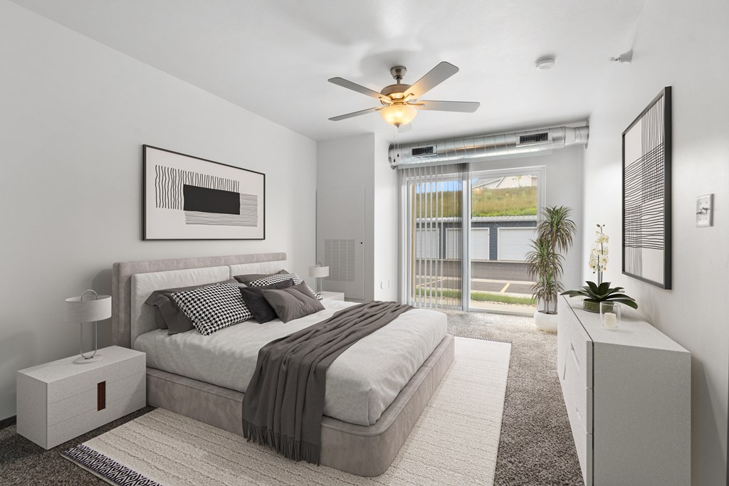 A bedroom with a large bed and a ceiling fan.