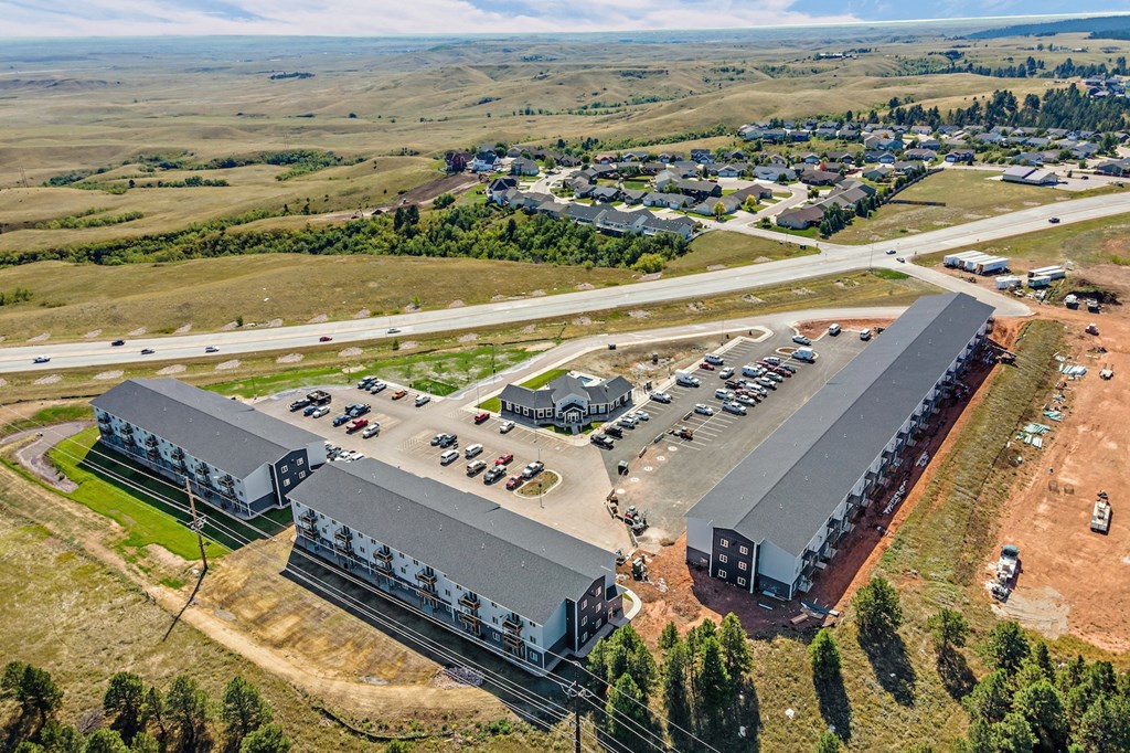 an aerial view of a building site with cars parked in a parking lot