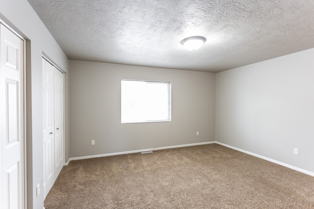 an empty room with carpet and a window