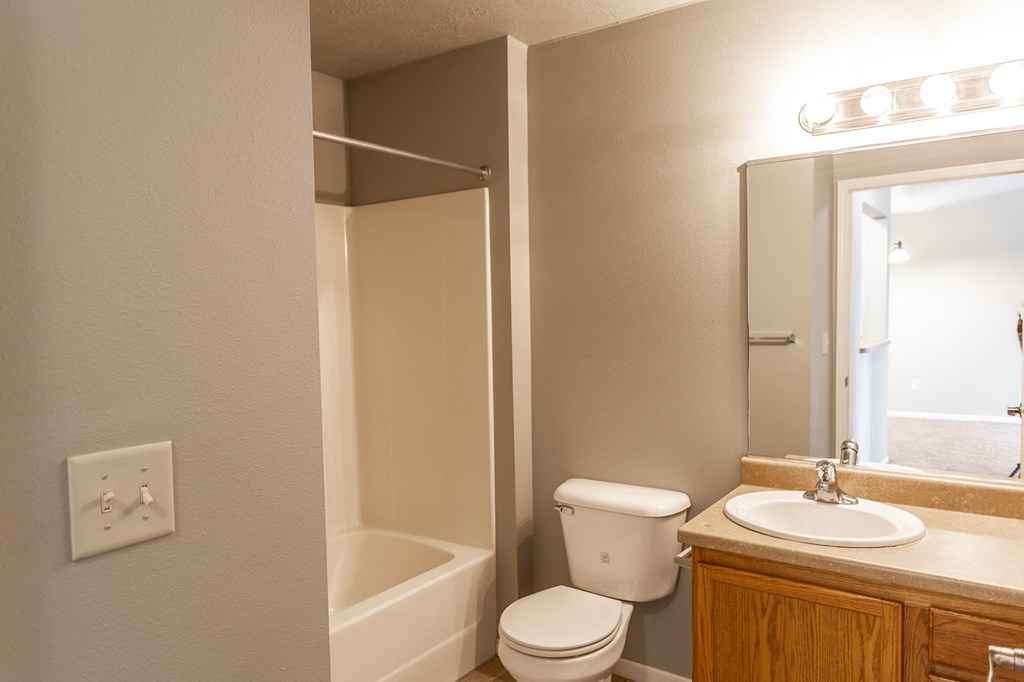 a bathroom with a toilet sink and shower and a mirror