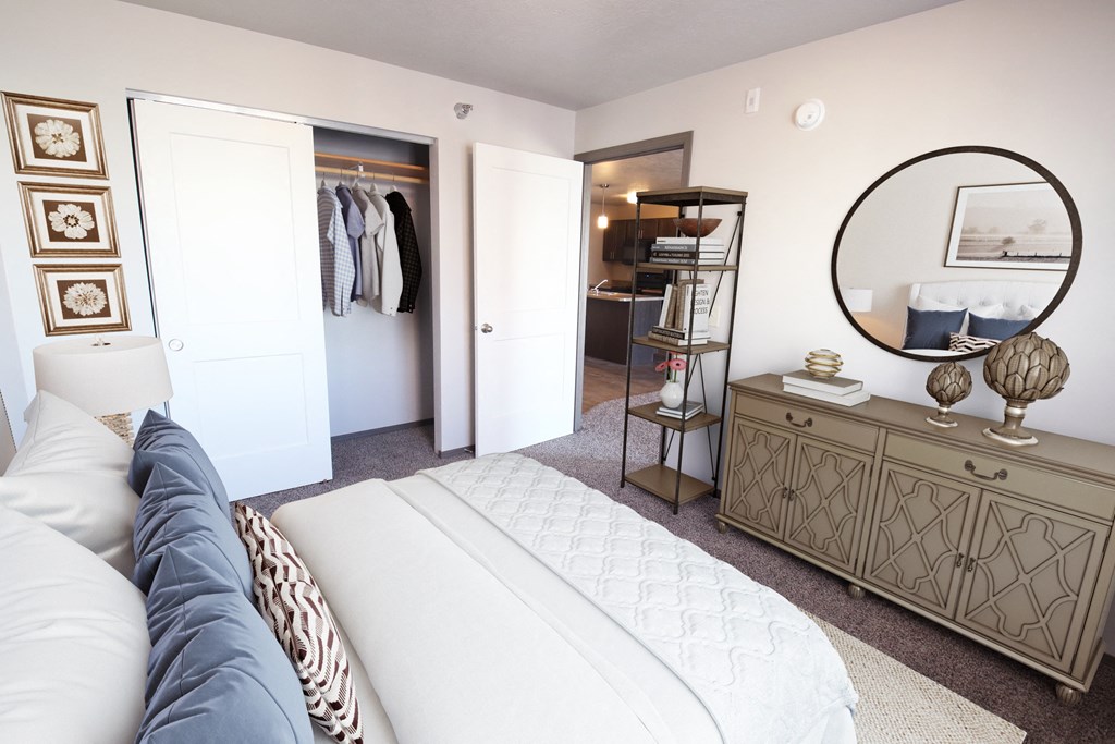 a bedroom with a bed and a dresser with a mirror and a closet