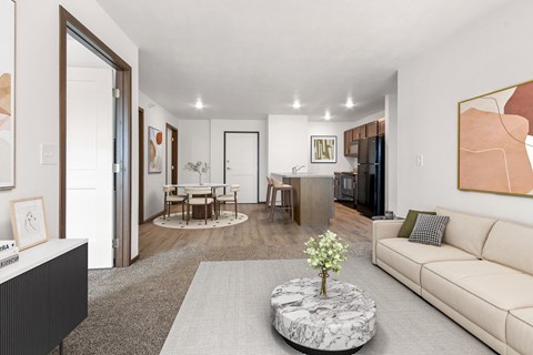 A living room with a white couch and a coffee table with a plant on it.