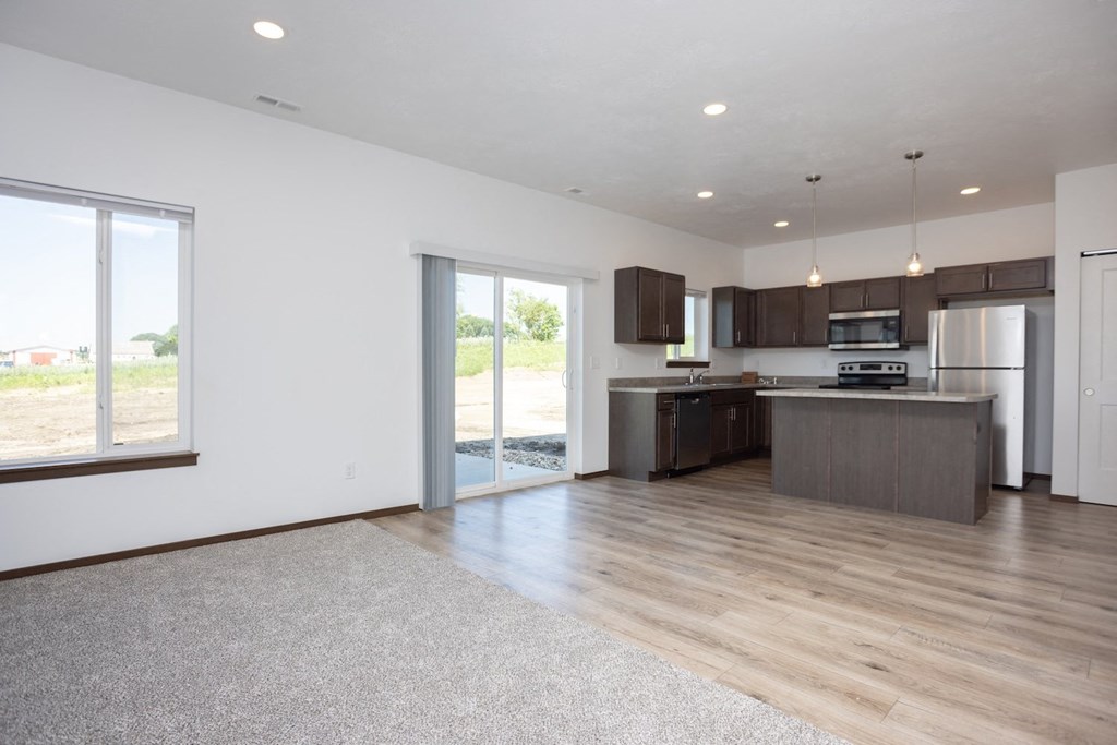 an open kitchen and living room with a sliding glass door to a patio