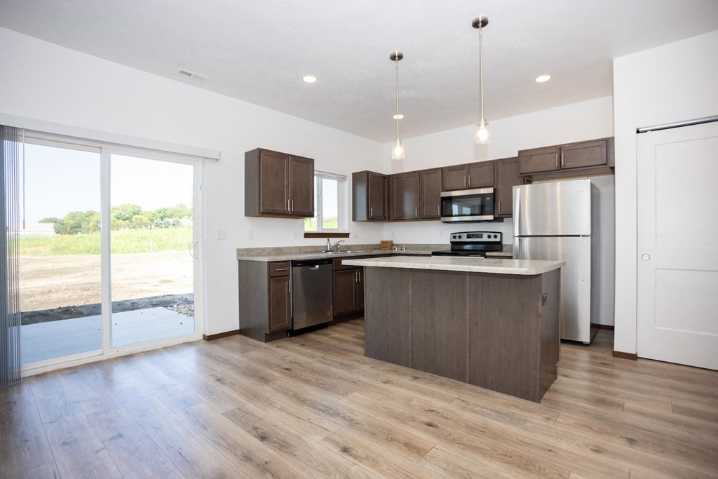 a large kitchen with wooden floors and stainless steel appliances