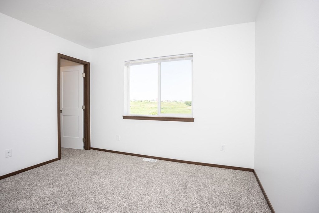 an empty room with a window and a door
