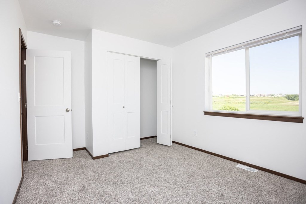 an empty room with two doors and a window