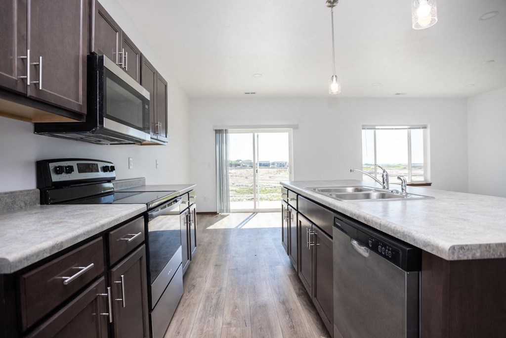 a large kitchen with stainless steel appliances and marble counter tops