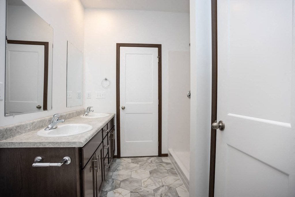 a bathroom with two sinks and a white door