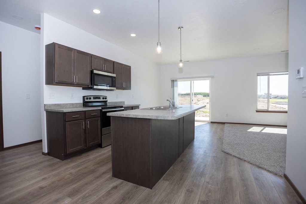 an empty kitchen with a large island in the middle