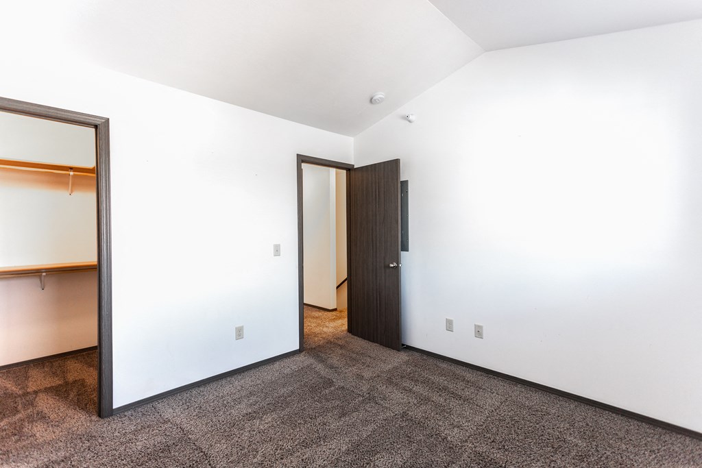 an empty room with a closet and a door to a bathroom