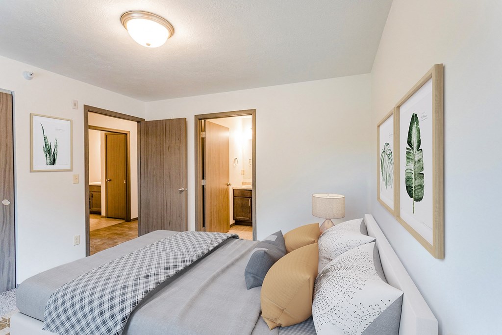 a bedroom with a bed and a bathroom with a closet