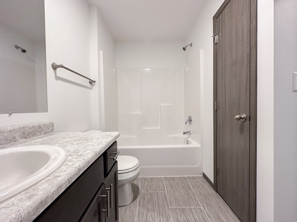 A bathroom with a sink, toilet, and bathtub.