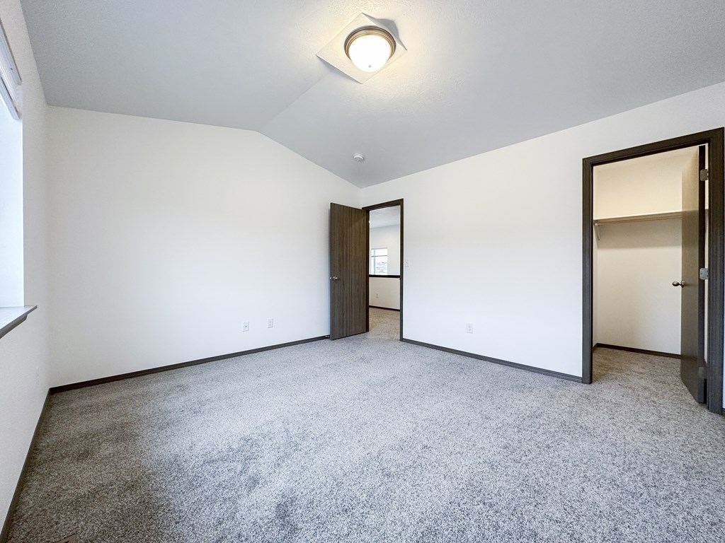 A room with a grey carpet and white walls.