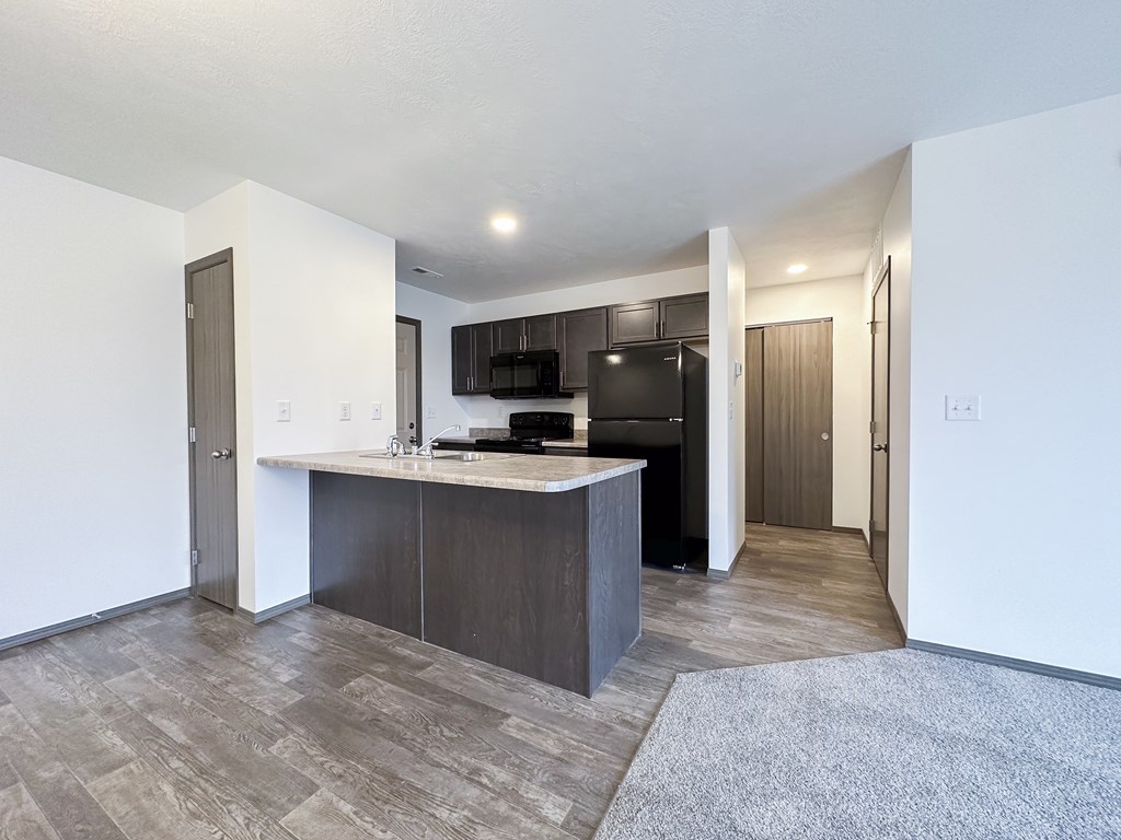 A modern kitchen with a large island and a TV mounted above it.