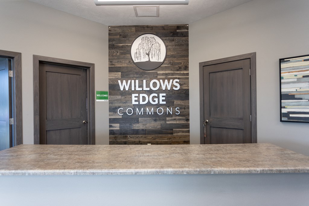 a lobby with a reception desk and a wall logo