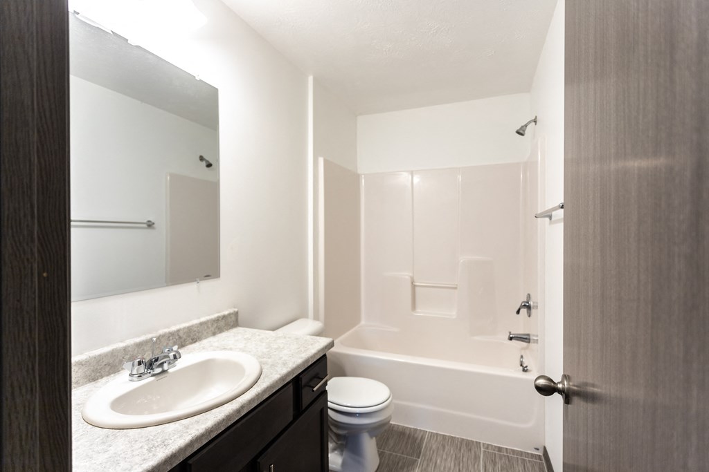 a bathroom with a sink toilet and shower and a mirror