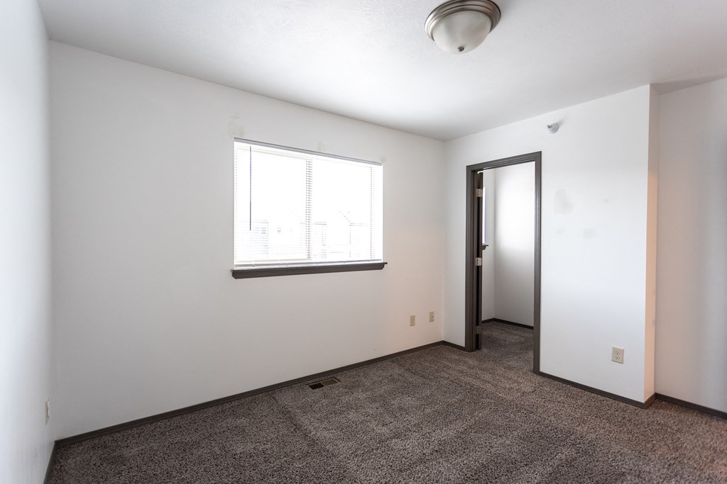 an empty living room with a window and a door
