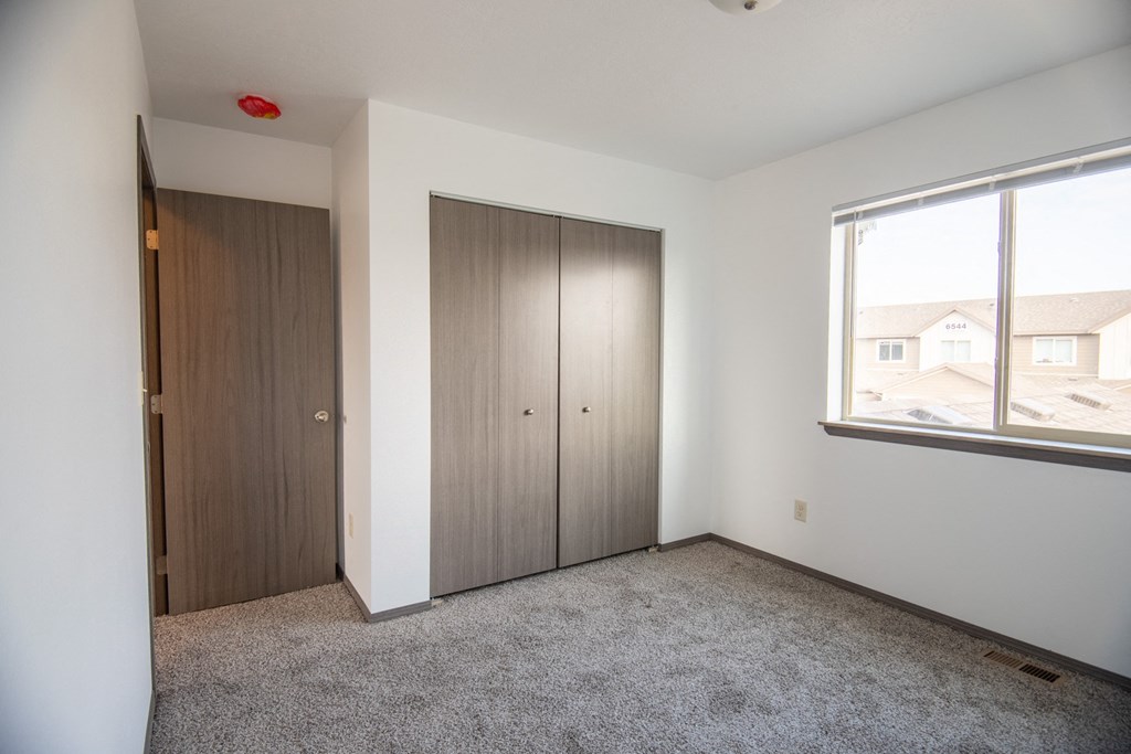 an empty room with two doors and a window